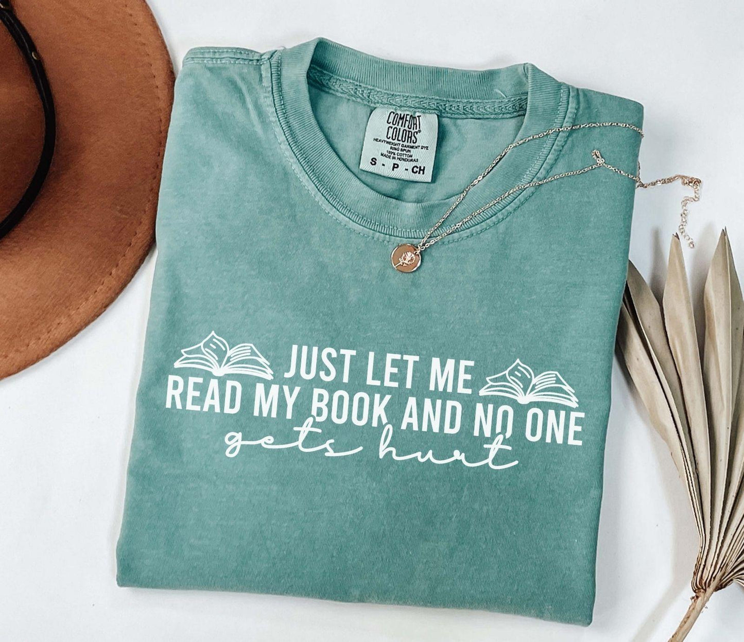 A comfort colors shirt with the saying "just let me read my book and no one gets hurt"