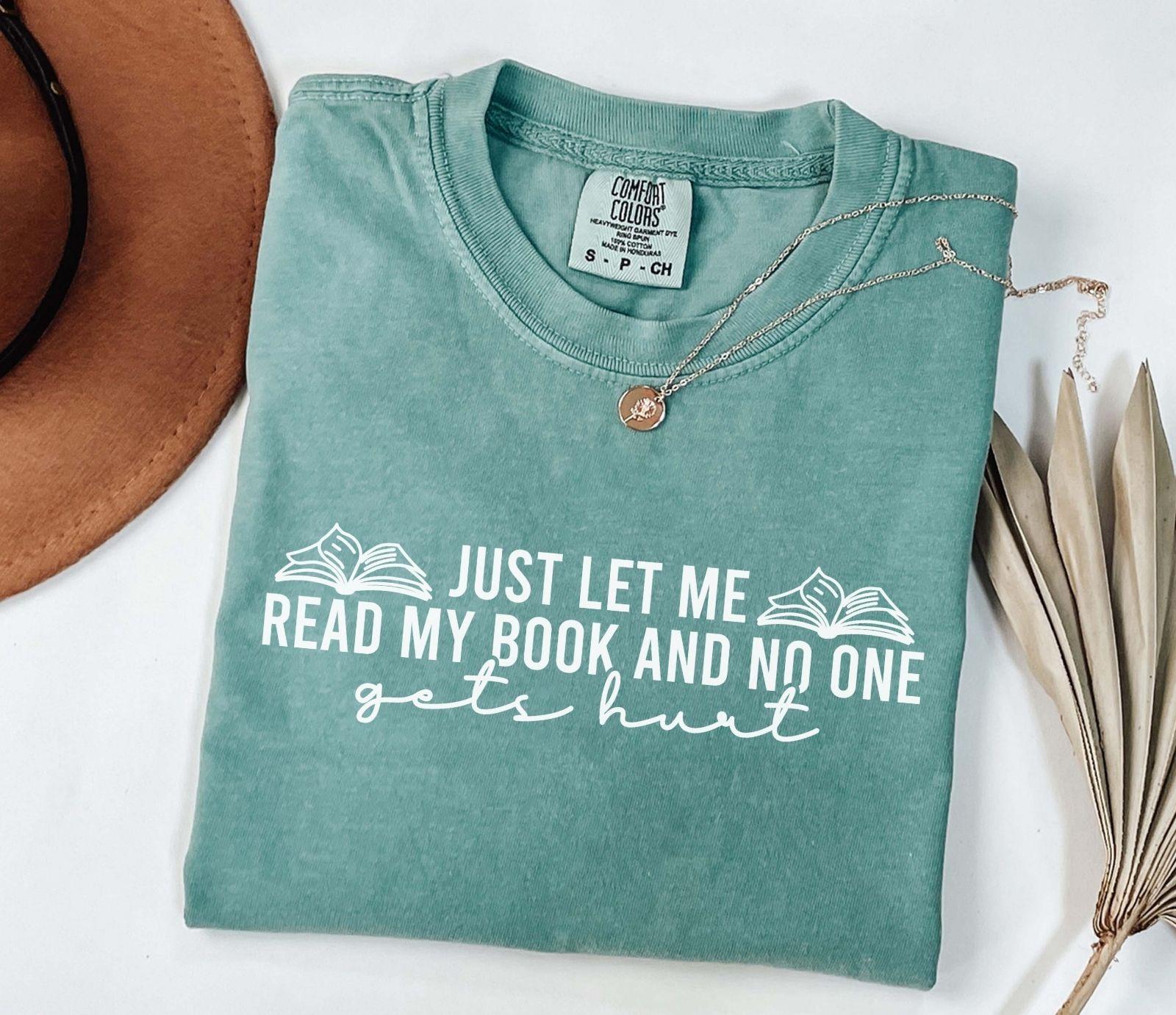 A comfort colors shirt with the saying "just let me read my book and no one gets hurt"