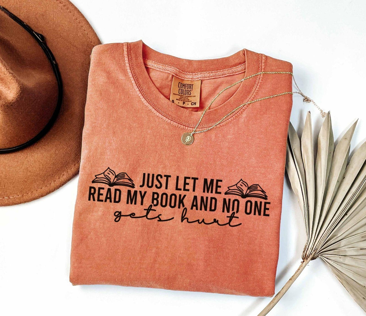 A comfort colors shirt with the saying "just let me read my book and no one gets hurt"