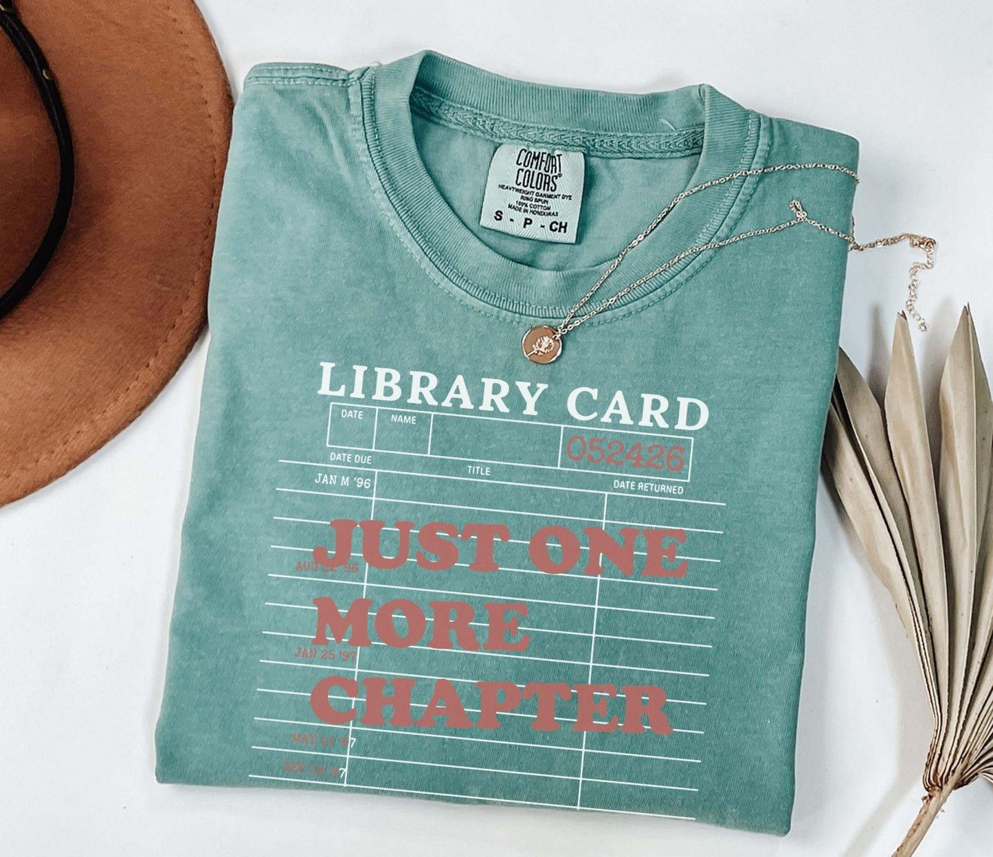 A comfort colors® shirt with the saying "just one more chapter"