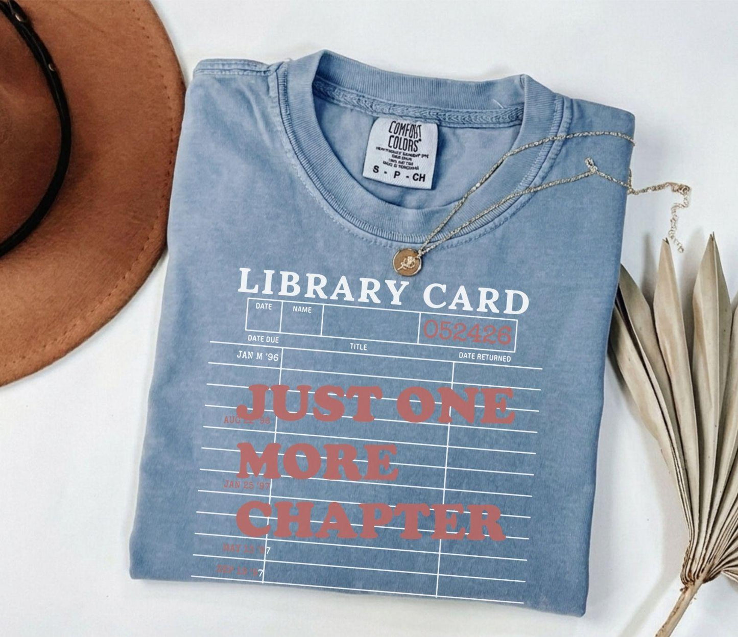 A comfort colors® shirt with the saying "just one more chapter"