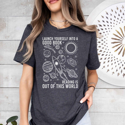 A bella canvas 3001 shirt with the saying "launch yourself into a good book reading is out of this world"