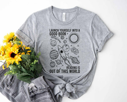 A bella canvas 3001 shirt with the saying "launch yourself into a good book reading is out of this world"