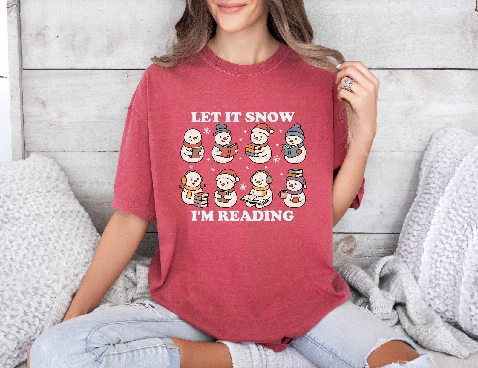 A comfort colors shirt with the saying "Let it snow I'm reading"