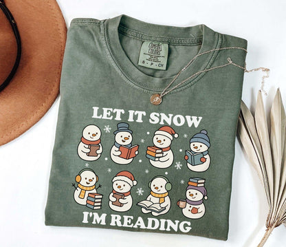 A comfort colors shirt with the saying "Let it snow I'm reading"