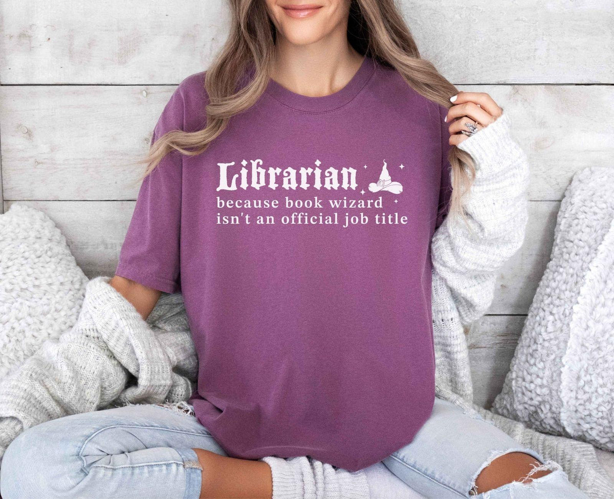 A comfort colors® shirt with the saying "librarian because book wizard isn't an official job title"