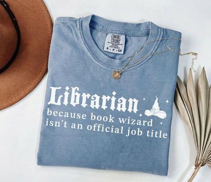 A comfort colors® shirt with the saying "librarian because book wizard isn't an official job title"
