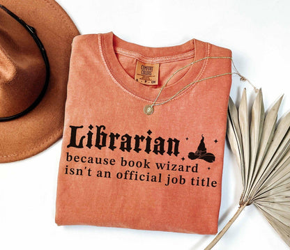 A comfort colors® shirt with the saying "librarian because book wizard isn't an official job title"