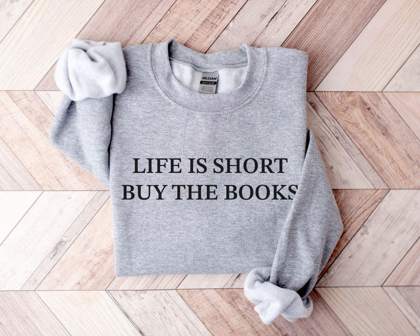 A Gildan 18000 sweatshirt with the saying "life is short buy the books"