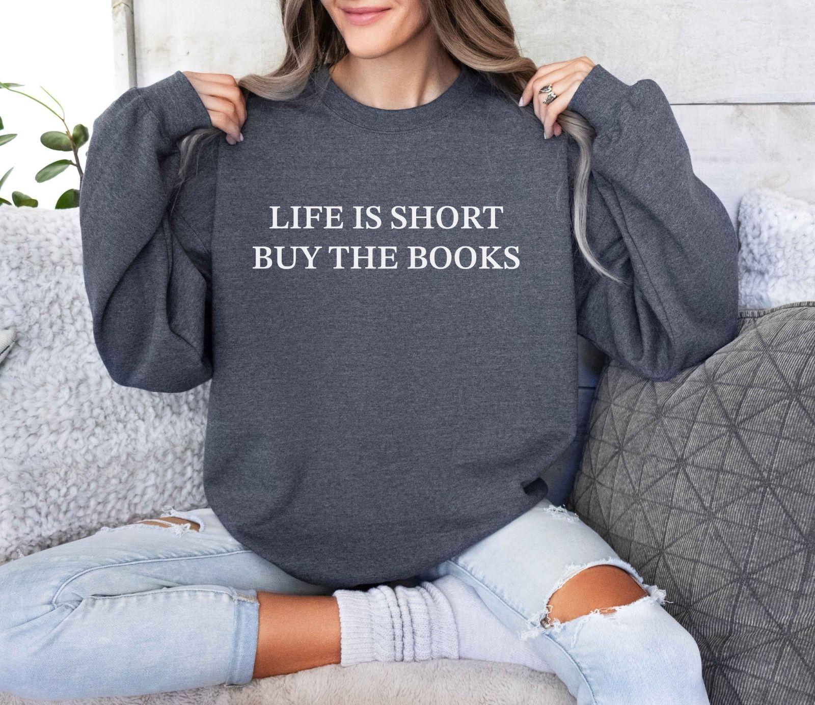 A Gildan 18000 sweatshirt with the saying "life is short buy the books"