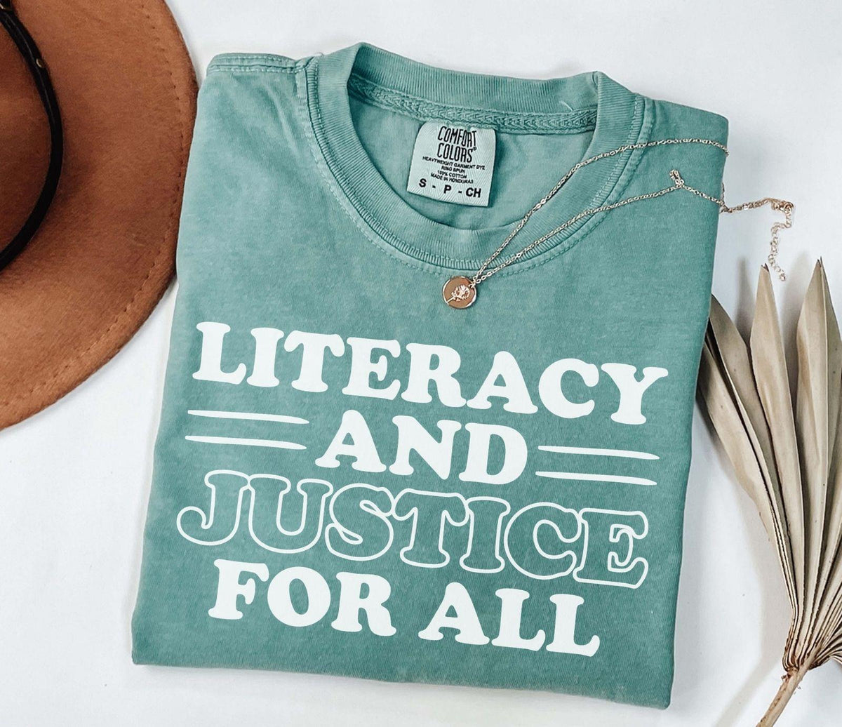 A comfort colors® shirt with the saying "Literacy and justice for all"