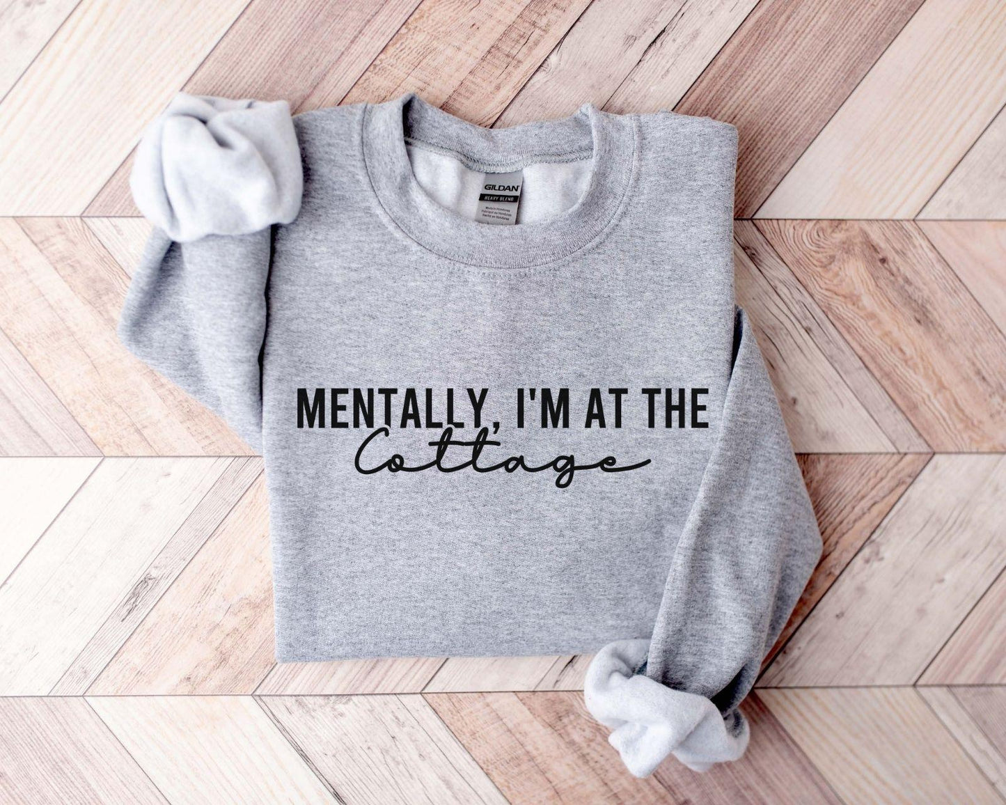 A Gildan 18000 sweatshirt with the saying "Mentally im at the cottage"