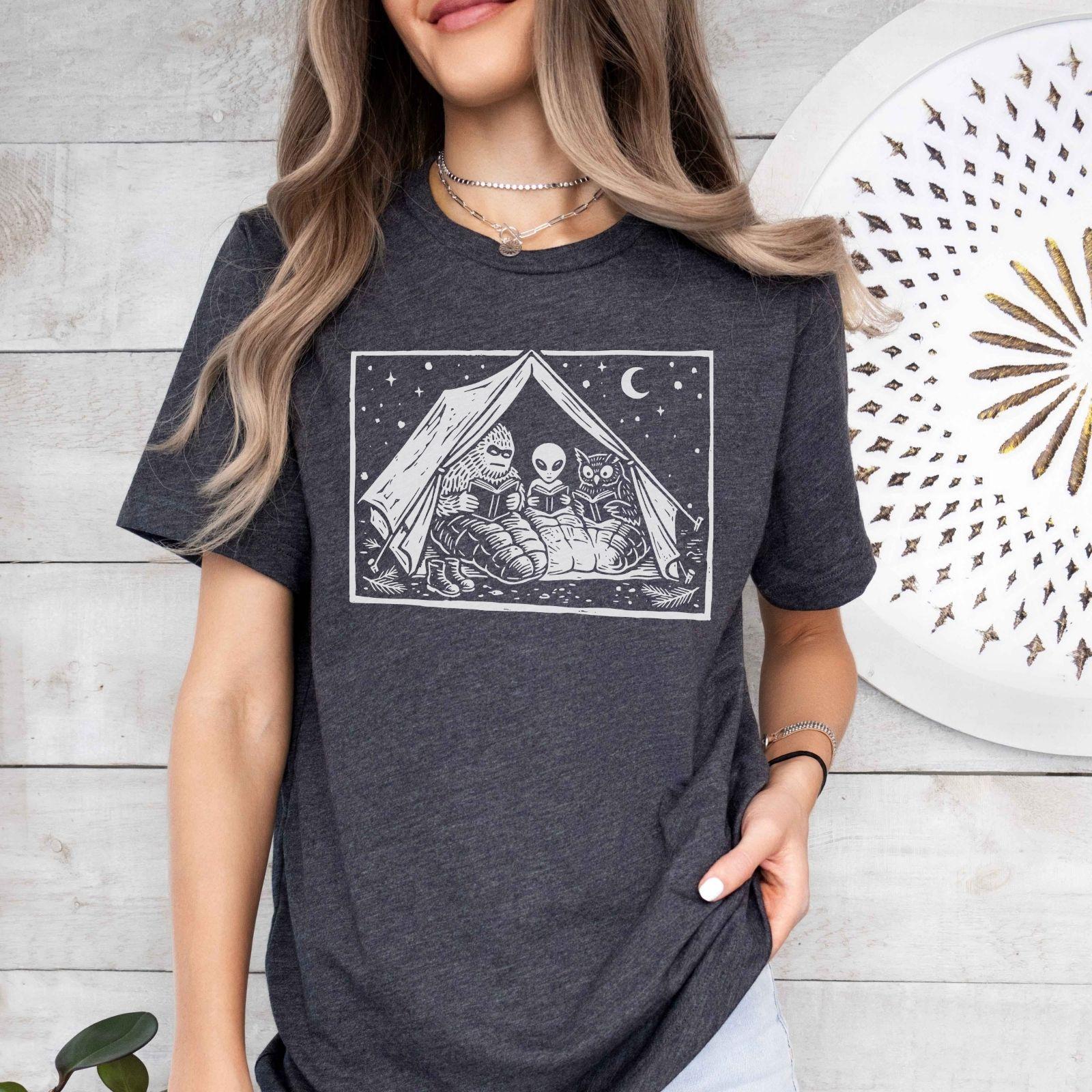 A bella canvas 3001 shirt with the saying "mothman, bigfoot and horned reading books"