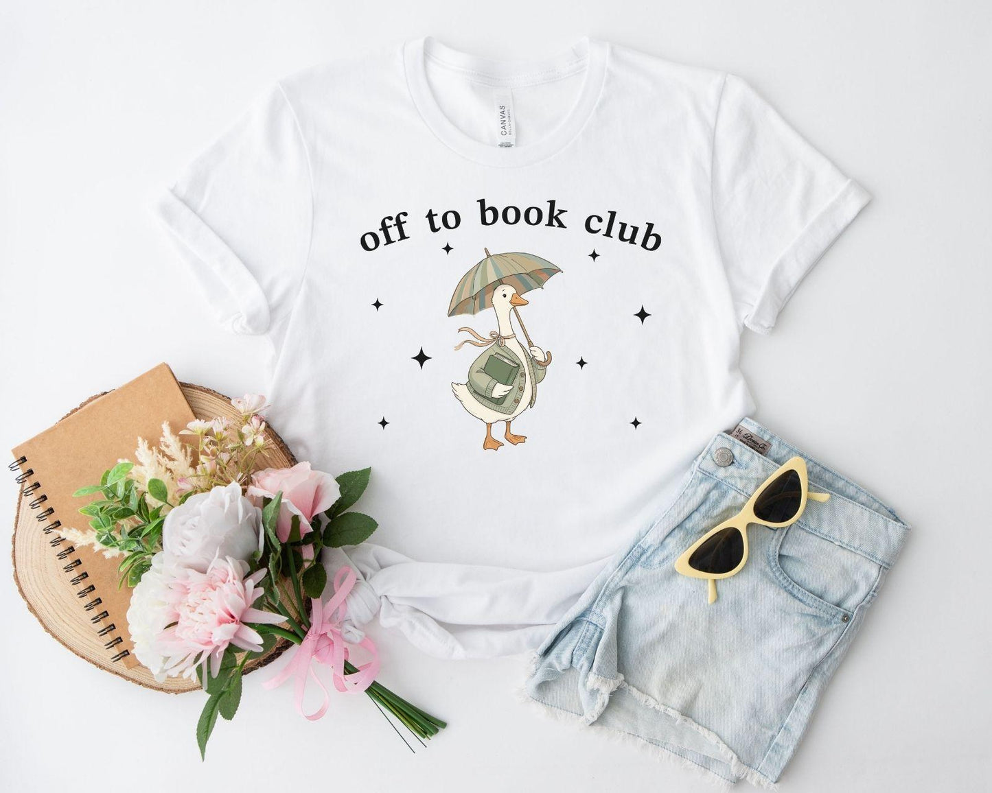 A bella canvas 3001 shirt with the saying "off to book club"