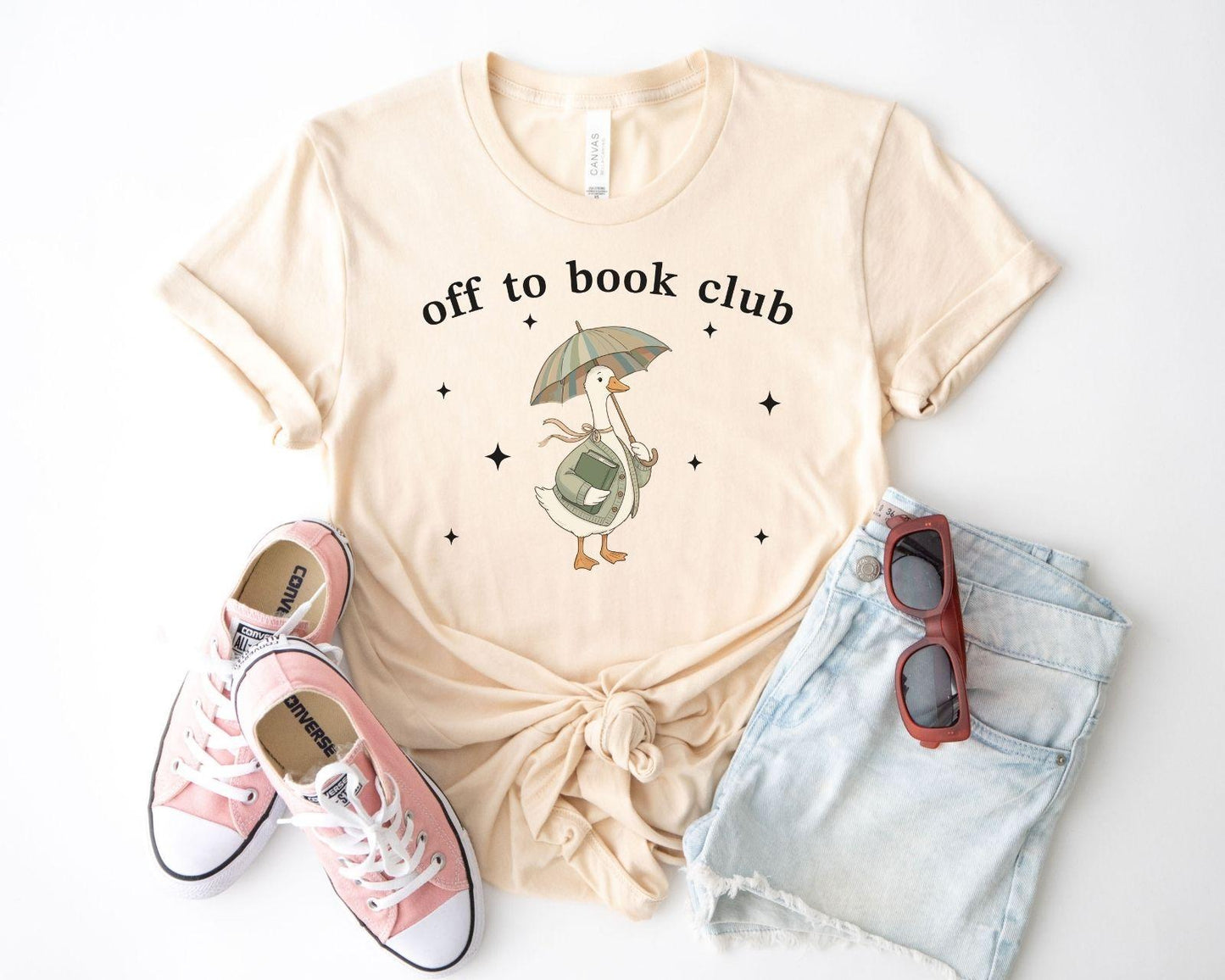 A bella canvas 3001 shirt with the saying "off to book club"