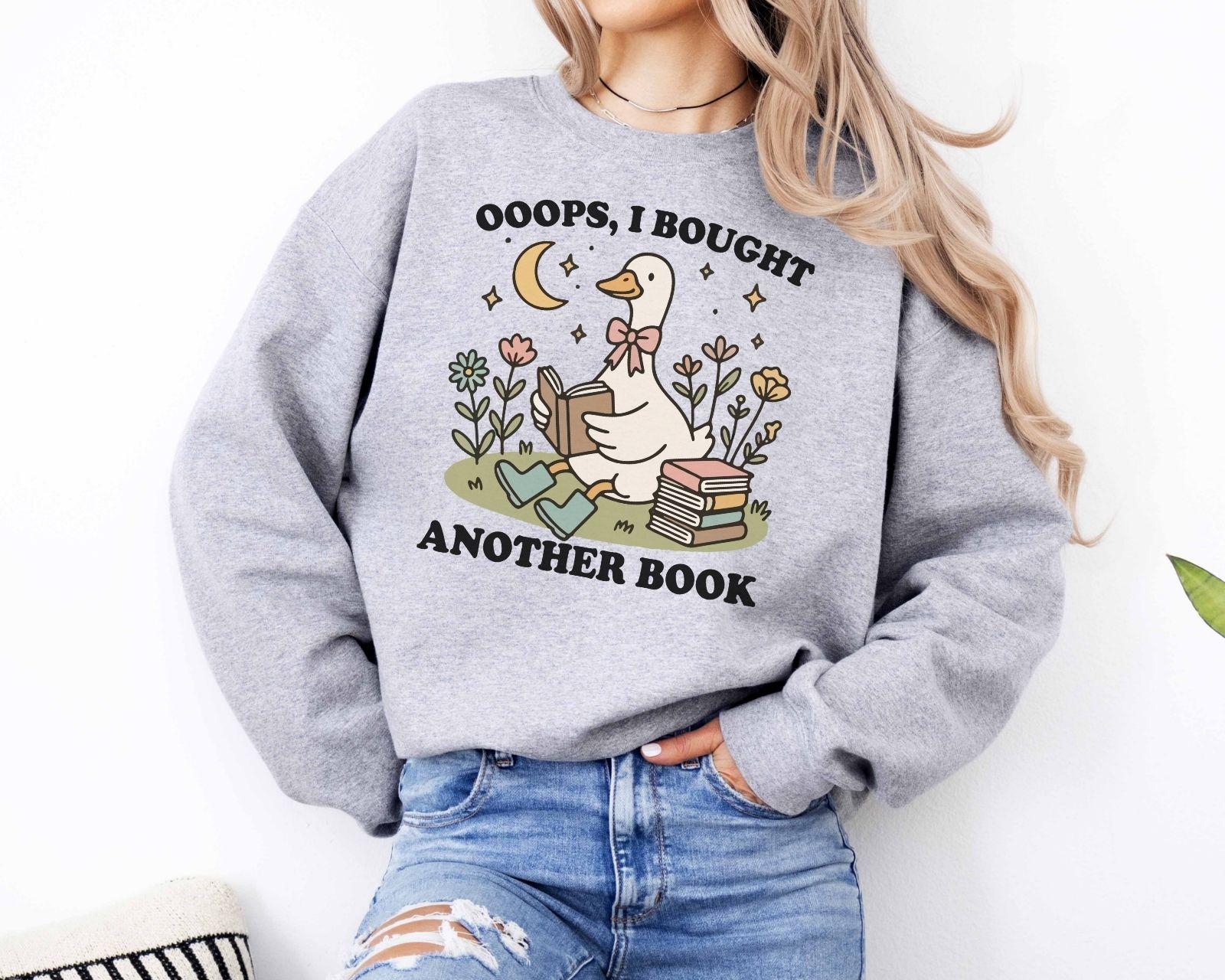 A Gildan 18000 sweatshirt with the saying "oops i bought another book"