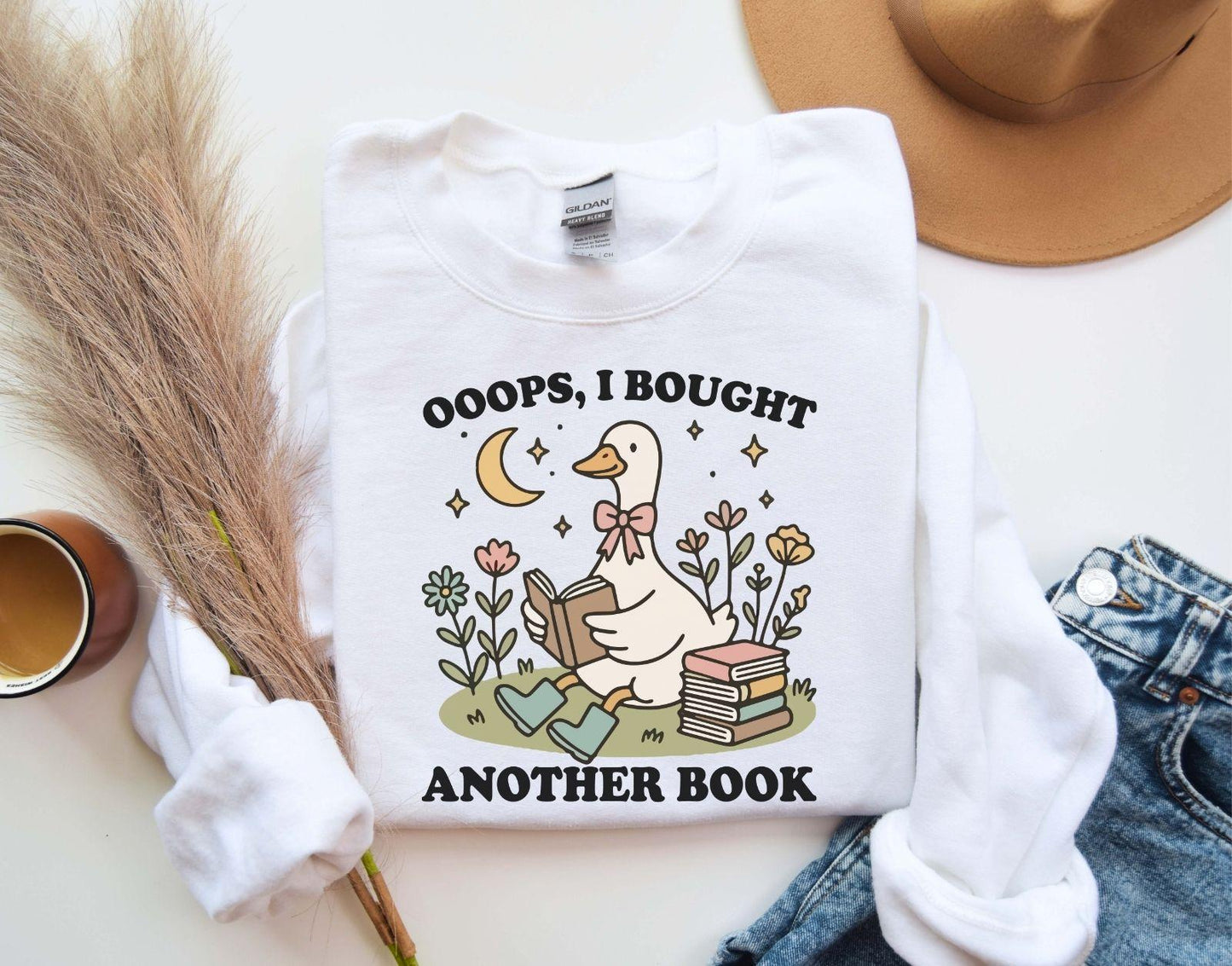 A Gildan 18000 sweatshirt with the saying "oops i bought another book"