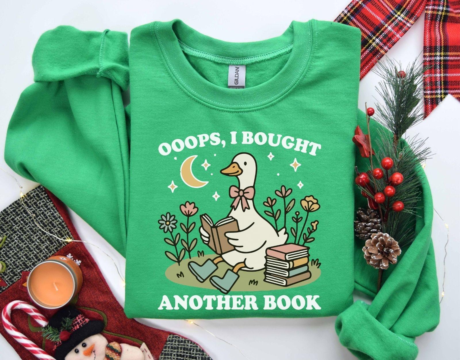 A Gildan 18000 sweatshirt with the saying "oops i bought another book"