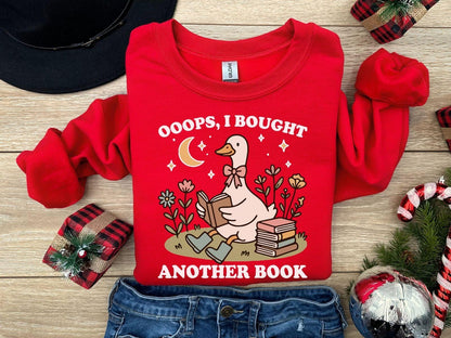 A Gildan 18000 sweatshirt with the saying "oops i bought another book"