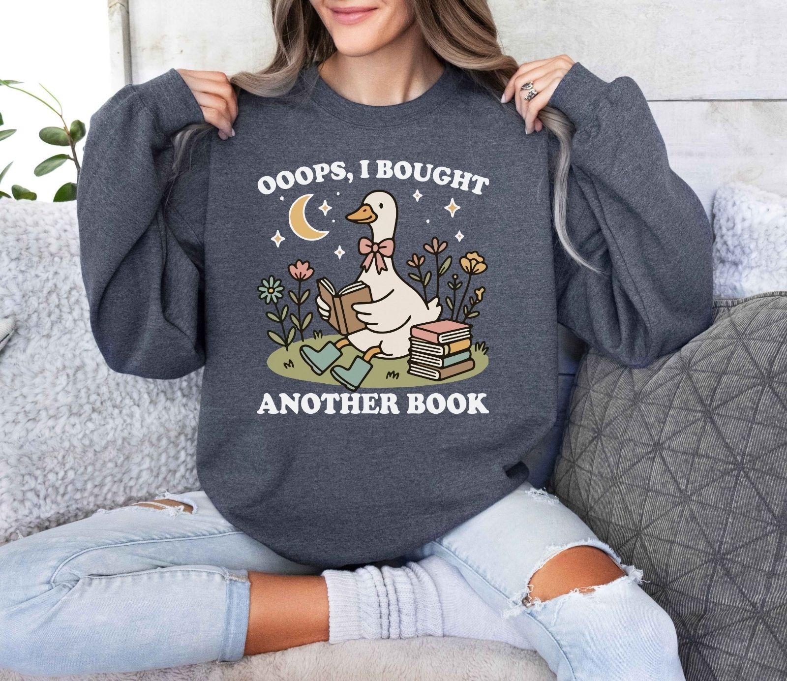 A Gildan 18000 sweatshirt with the saying "oops i bought another book"
