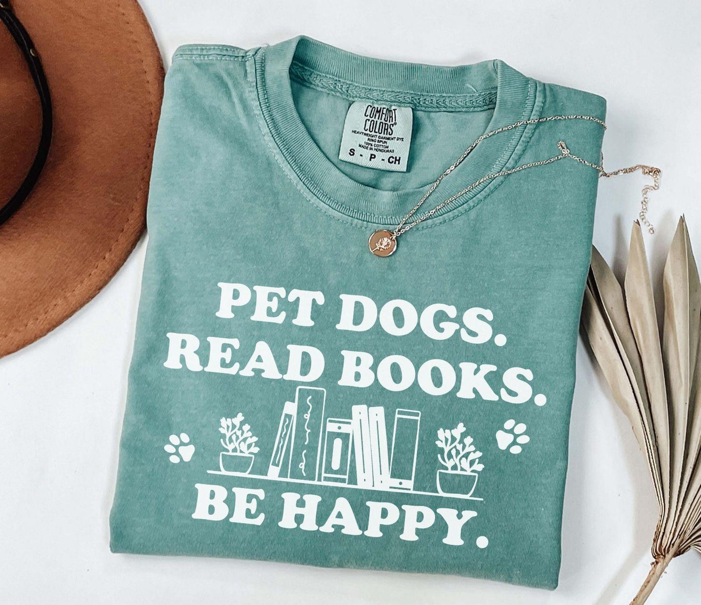 A comfort colors shirt with the saying "Pet dogs read books be happy"