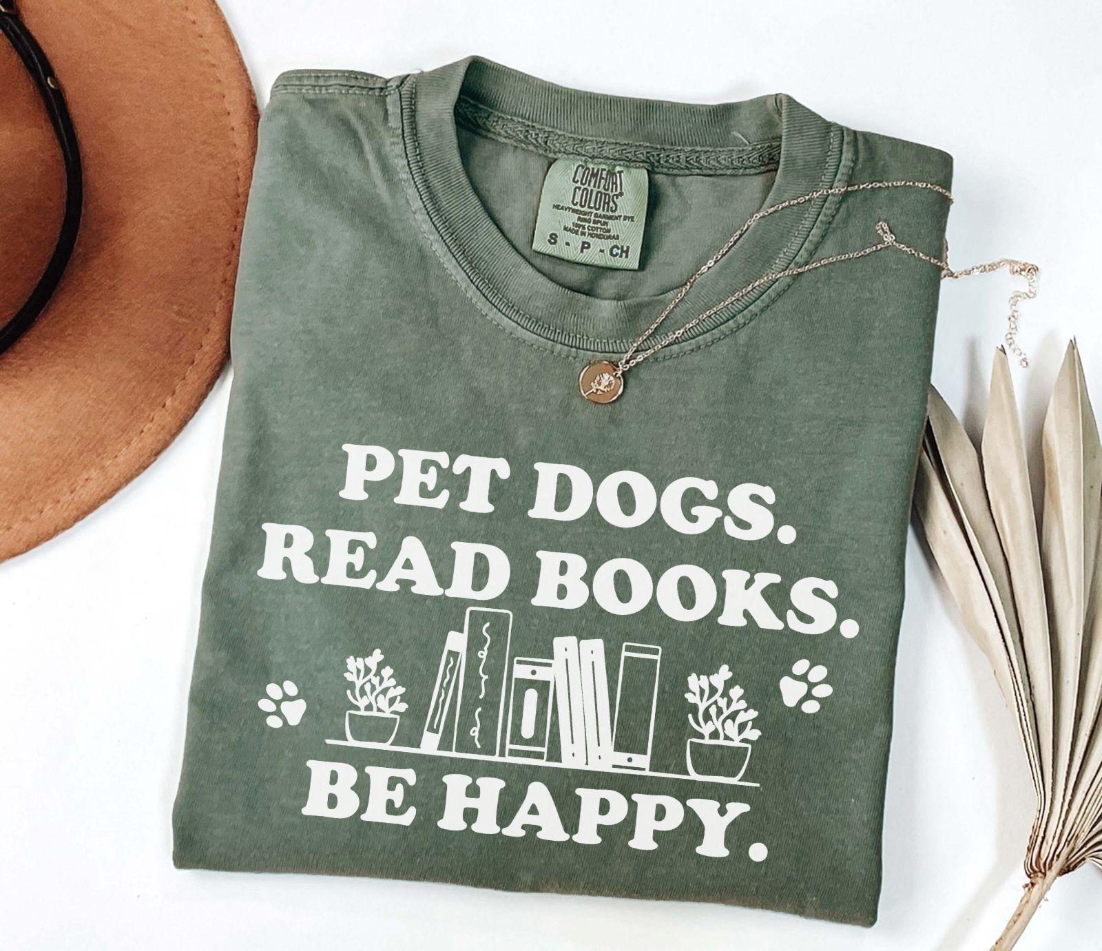 A comfort colors shirt with the saying "Pet dogs read books be happy"
