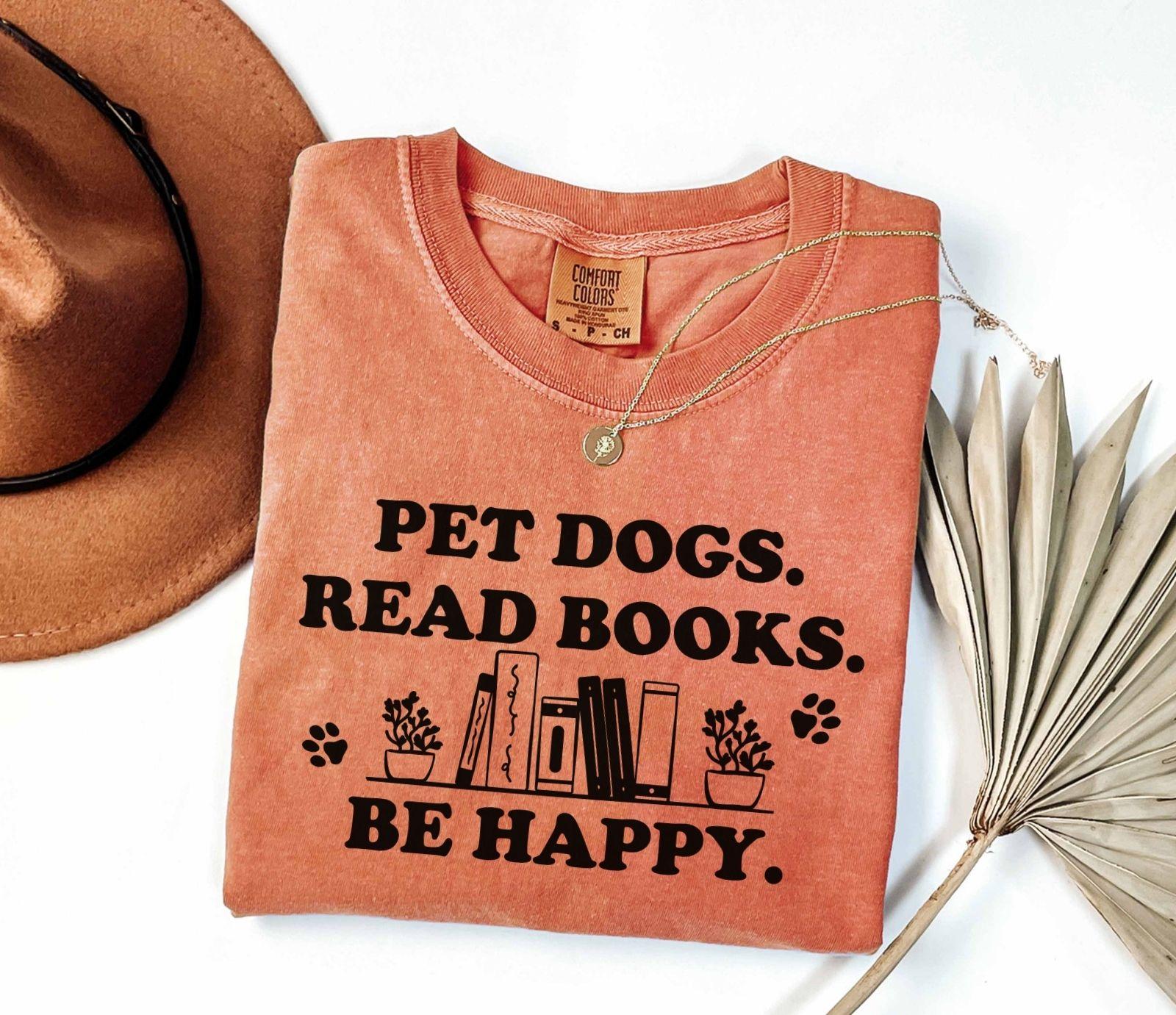 A comfort colors shirt with the saying "Pet dogs read books be happy"