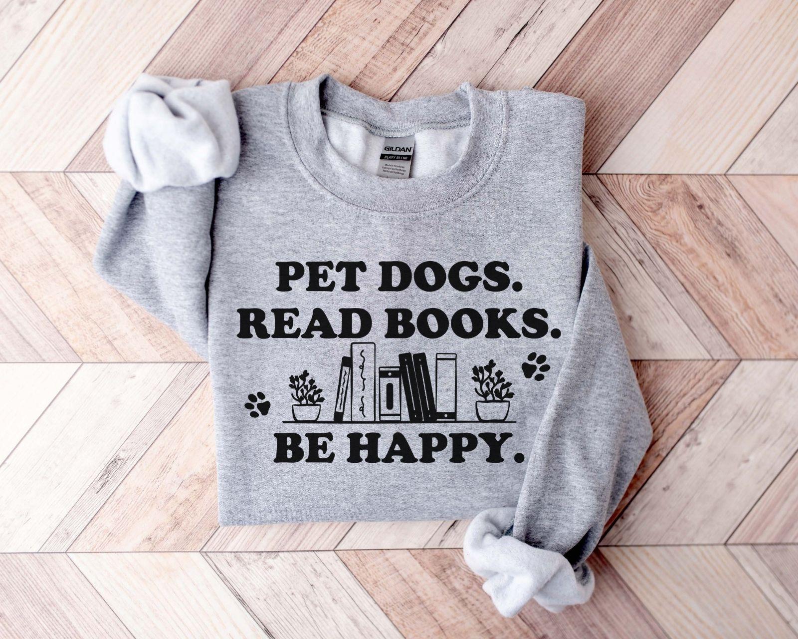 A gildan 18000 sweatshirt with the saying "Pet dogs read books be happy"