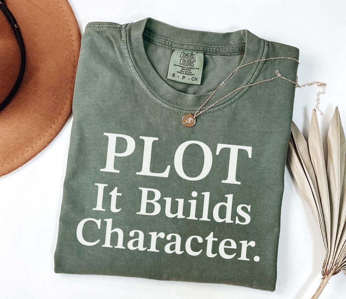 A comfort colors® shirt with the saying "Plot it builds character"