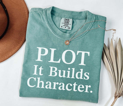 A comfort colors® shirt with the saying "Plot it builds character"
