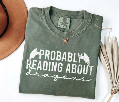 A comfort colors® shirt with the saying "Probably reading about dragons"