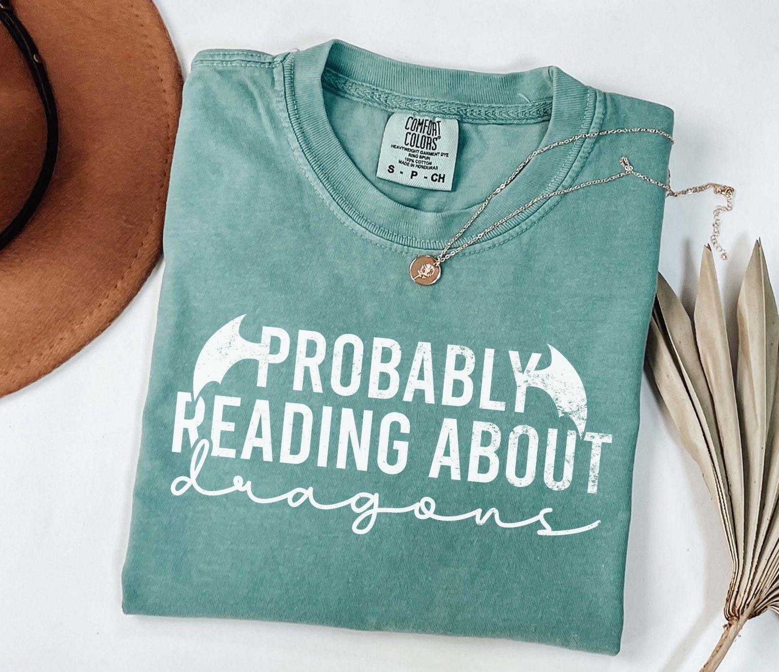 A comfort colors® shirt with the saying "Probably reading about dragons"