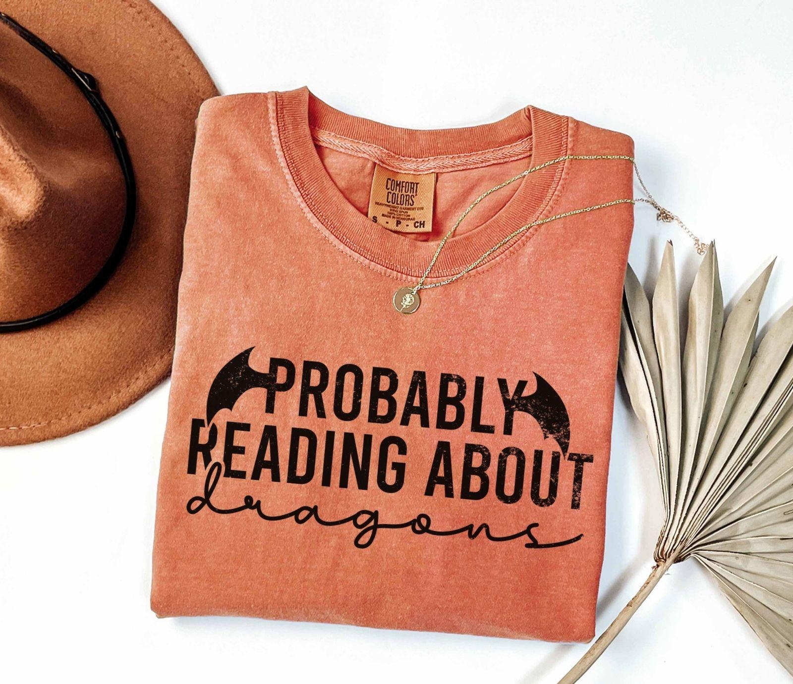 A comfort colors® shirt with the saying "Probably reading about dragons"