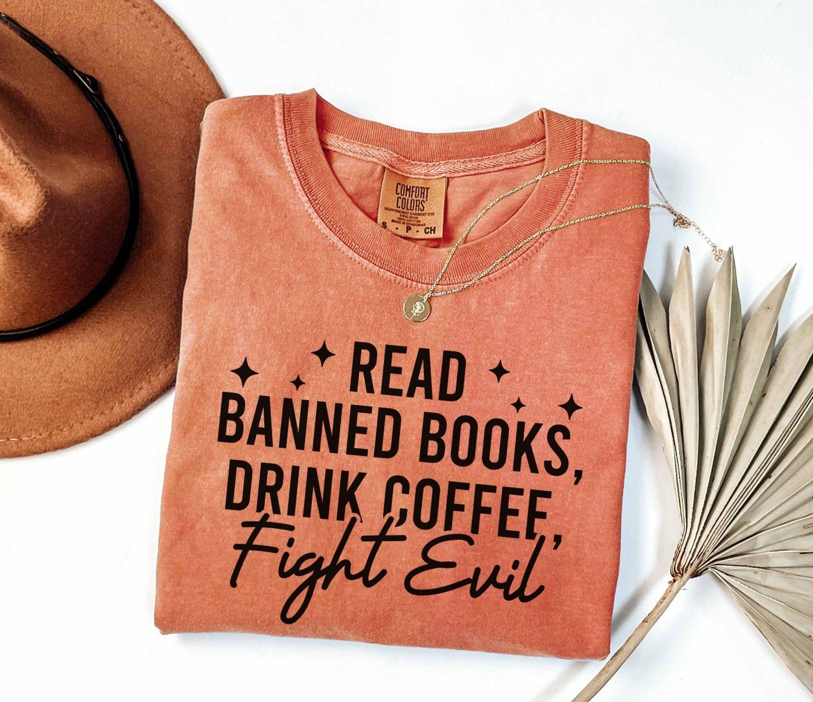 A comfort colors shirt with the saying "Read banned books drink coffee fight evil"