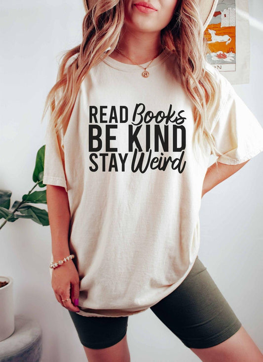 A comfort colors shirt with the saying "read books be kind stay weird"
