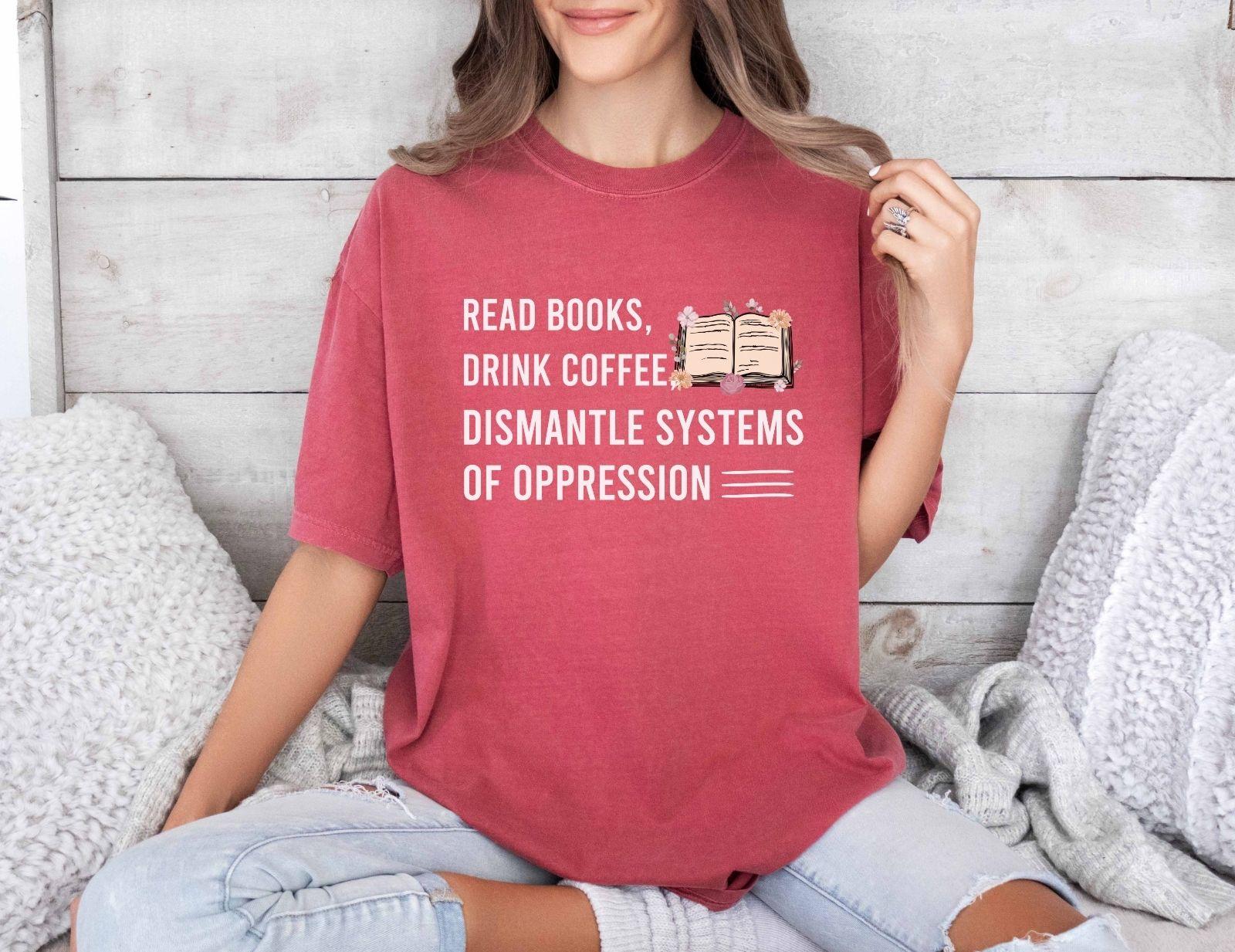 A comfort colors shirt with the saying "Read books drink coffee dismantle systems of oppression"