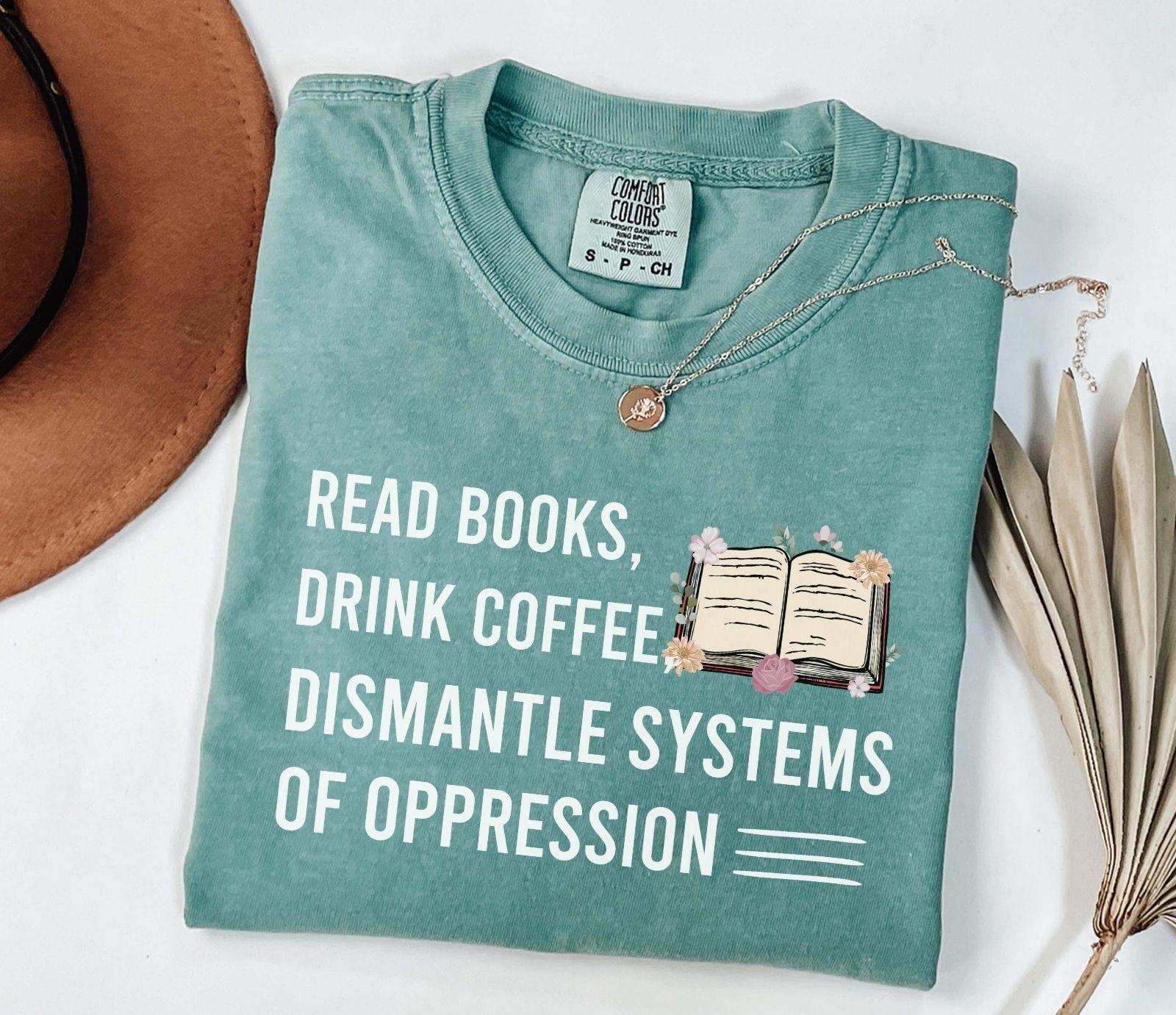 A comfort colors shirt with the saying "Read books drink coffee dismantle systems of oppression"