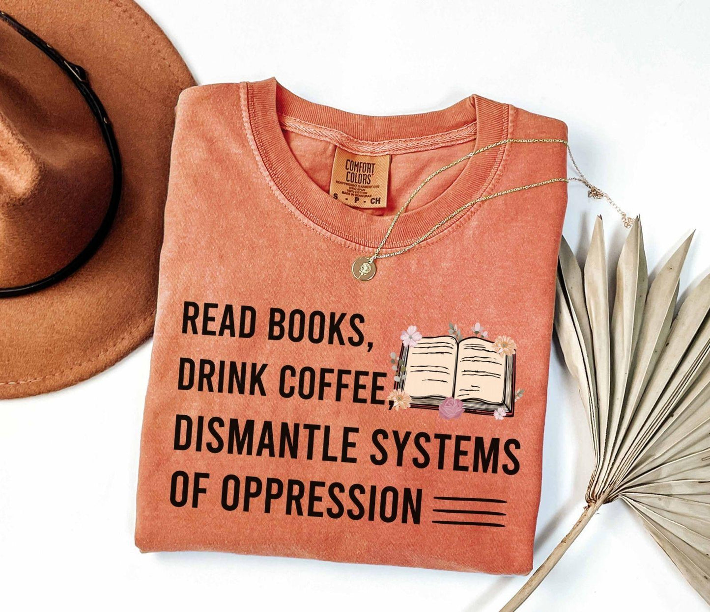 A comfort colors shirt with the saying "Read books drink coffee dismantle systems of oppression"