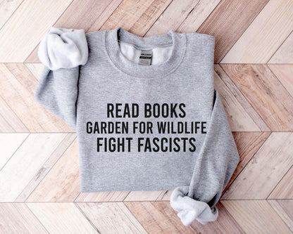 A Gildan 18000 sweatshirt with the saying "Read books garden for wildlife fight fascists"
