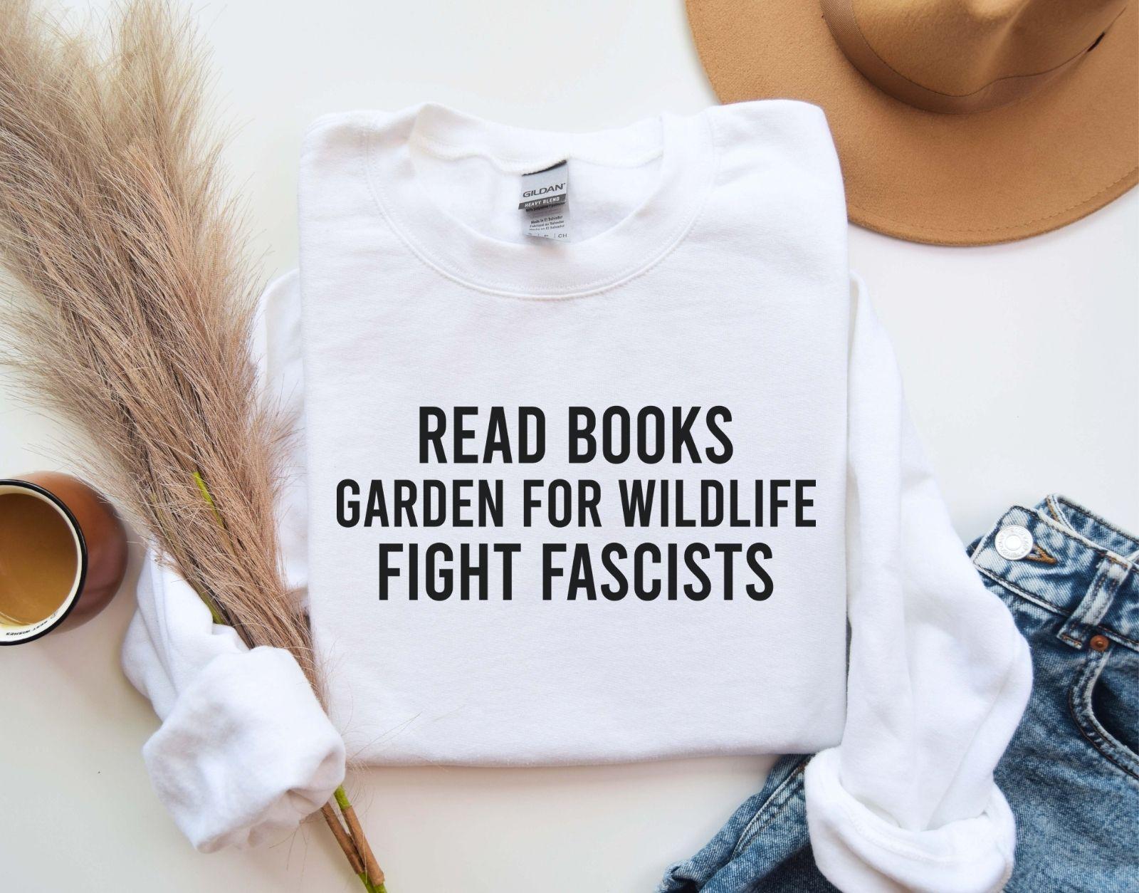 A Gildan 18000 sweatshirt with the saying "Read books garden for wildlife fight fascists"