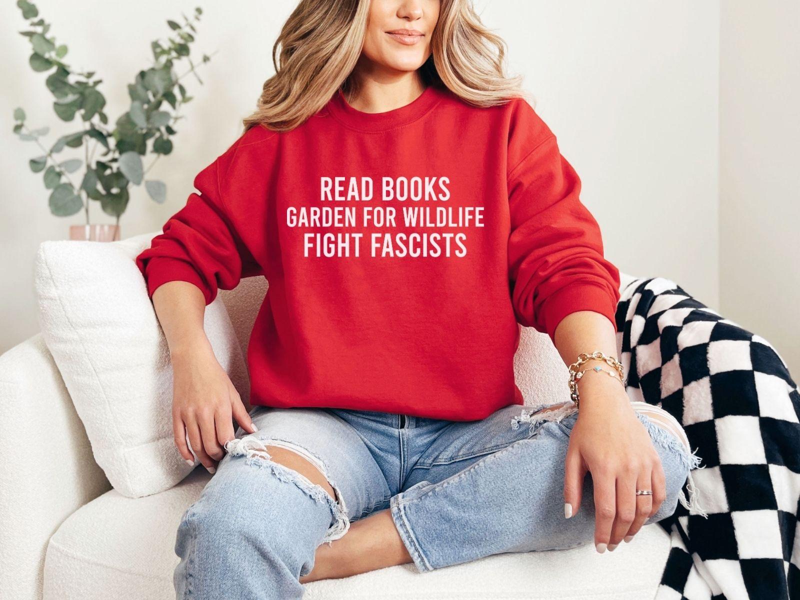 A Gildan 18000 sweatshirt with the saying "Read books garden for wildlife fight fascists"