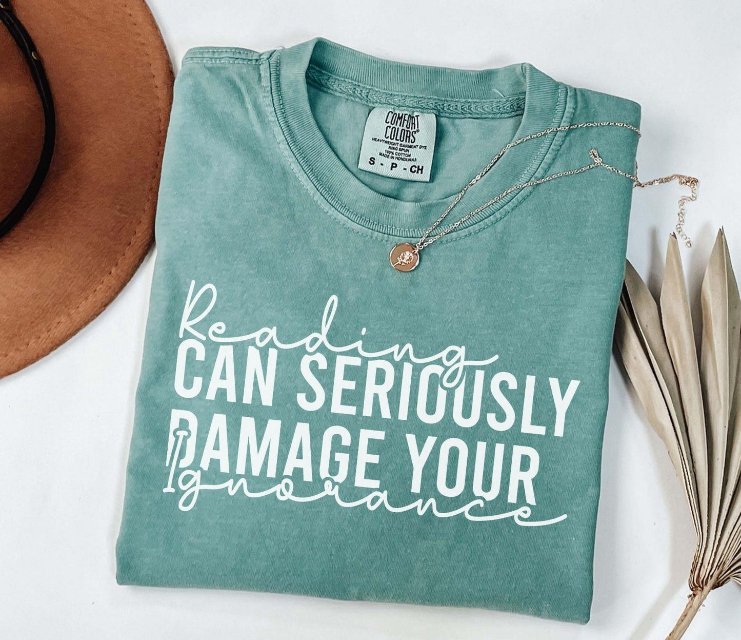 A comfort colors® shirt with the saying "Reading can seriously damage your ignorance"