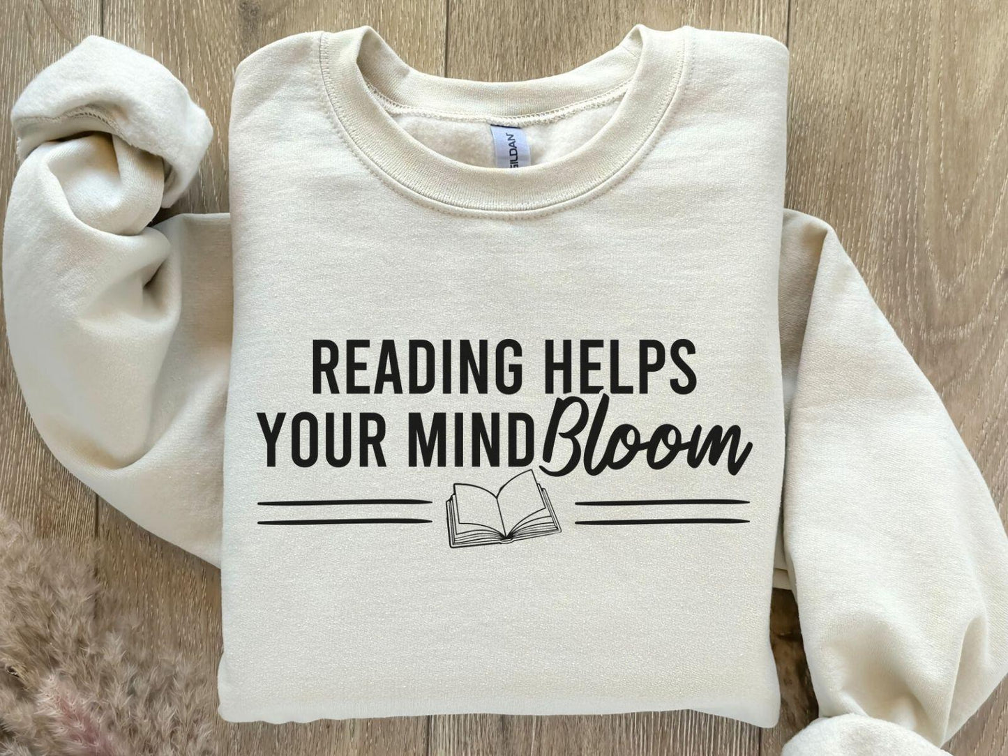 A Gildan 18000 sweatshirt with the saying "reading helps your mind bloom"