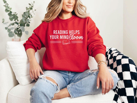 A Gildan 18000 sweatshirt with the saying "reading helps your mind bloom"