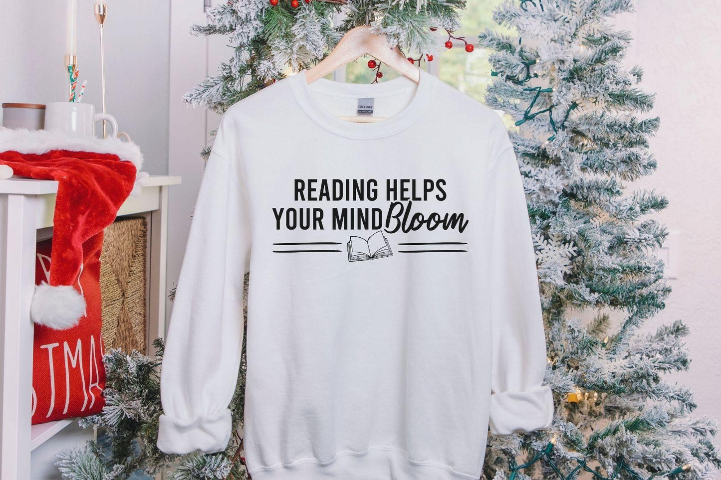 A Gildan 18000 sweatshirt with the saying "reading helps your mind bloom"