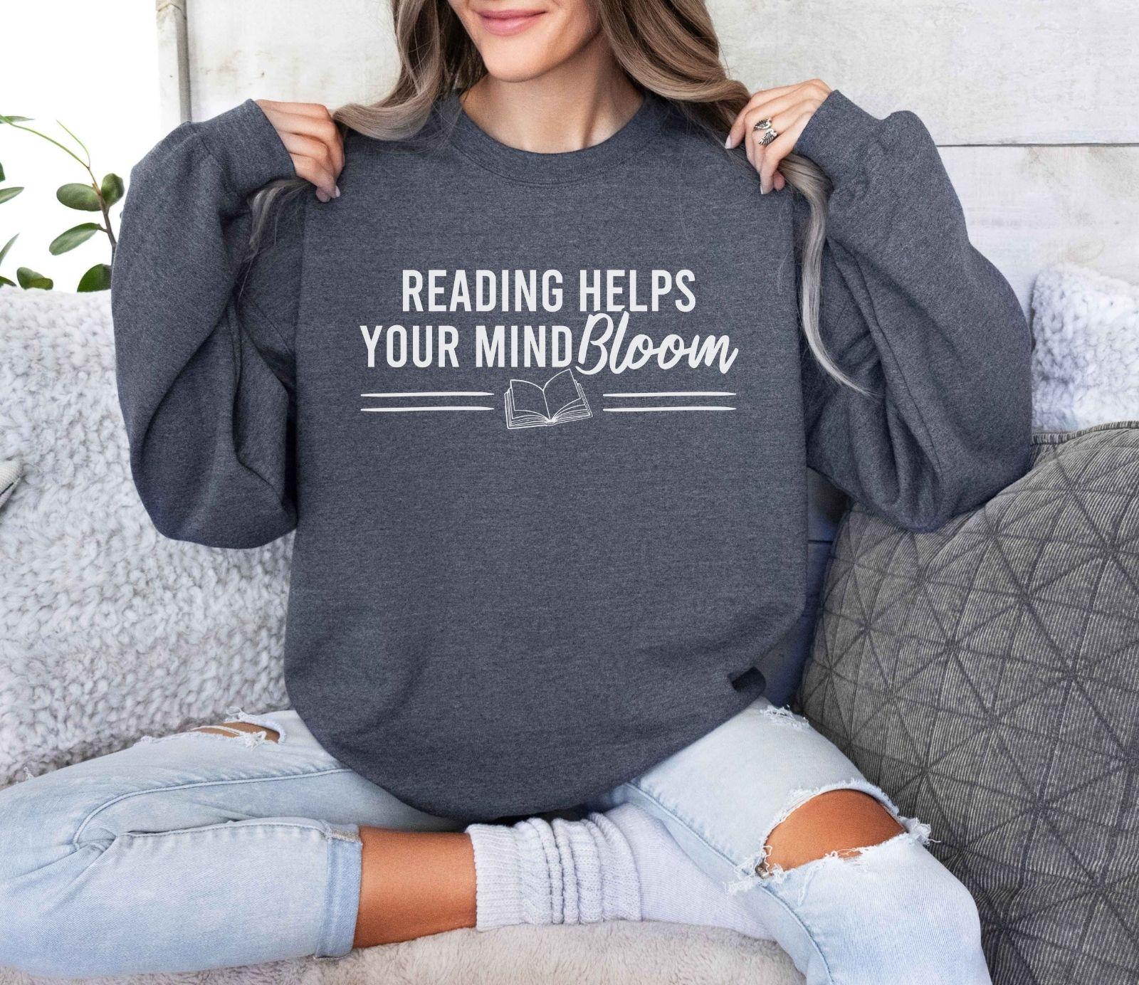 A Gildan 18000 sweatshirt with the saying "reading helps your mind bloom"