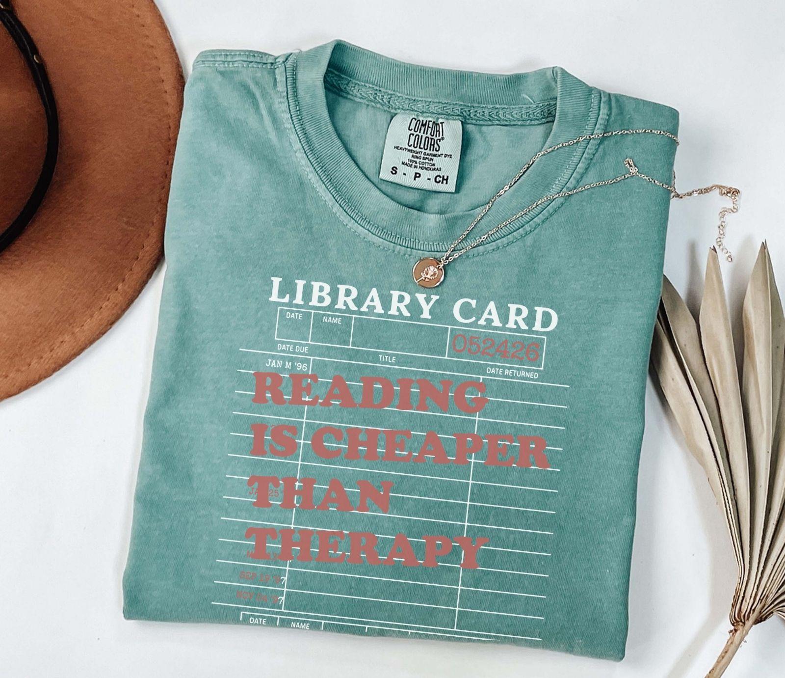 A comfort colors® shirt with the saying "reading is cheaper than therapy"