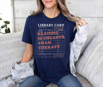 A bella canvas 3001 shirt with the saying "Reading is cheaper than therapy"