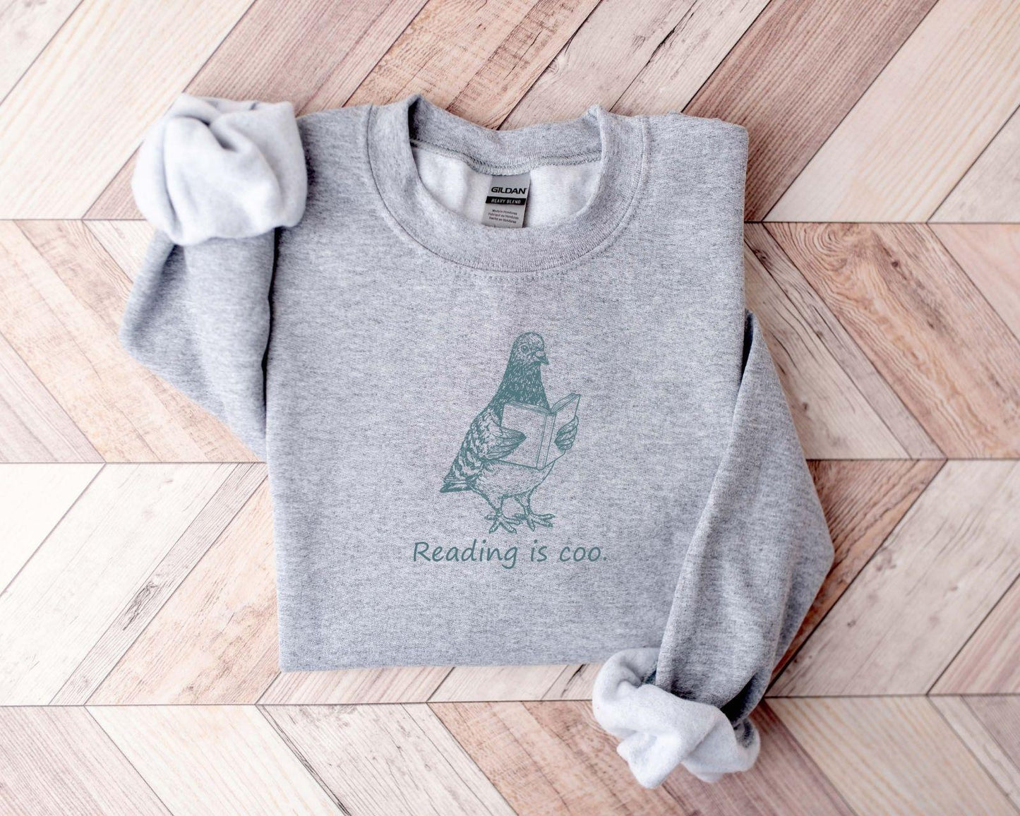 A Gildan 18000 sweatshirt with the saying "reading is coo"