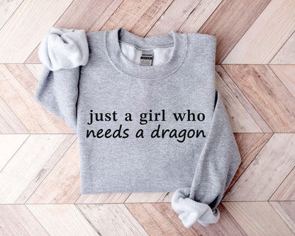 A Gildan 18000 sweatshirt with the saying "just a girl who needs a dragon"